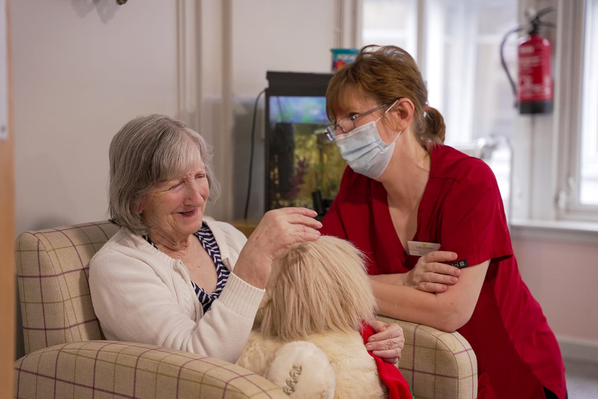 Resident and activity coordinator chatting in the day lounge at Cranford Care Home in Aberdeen.