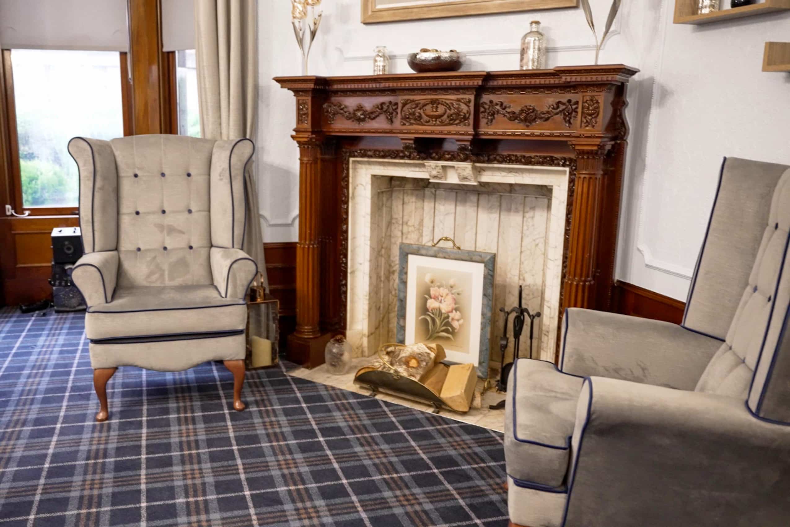 Cranford Care Home Aberdeen, front of house lounge with character fireplace and arm chairs.