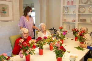 Residents enjoying a colourful flower arranging activity at Great Horkesley Manor Care Home near Colchester.