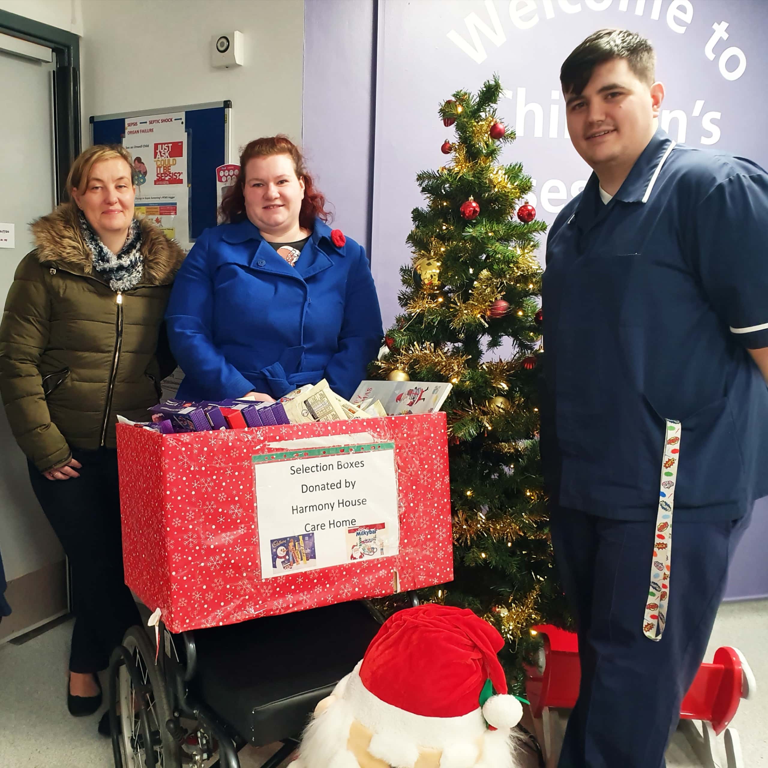 Harmony House Care Home Manager Karin Scott and Activities Coordinator Hayley Gibbs deliver a donation of 60 selection boxes to patients at Children's A&E at the George Elliot Hospital in Nuneaton.