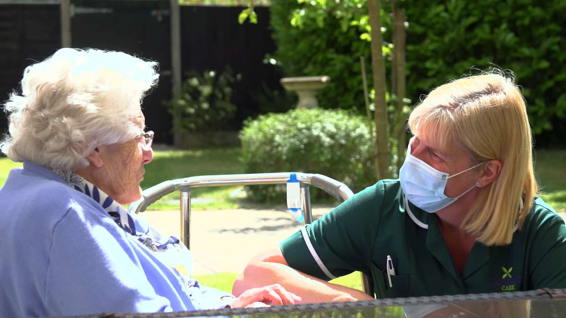 A resident and the activity coordinator enjoying a chat in the garden at Lily House Care Home in Ely.