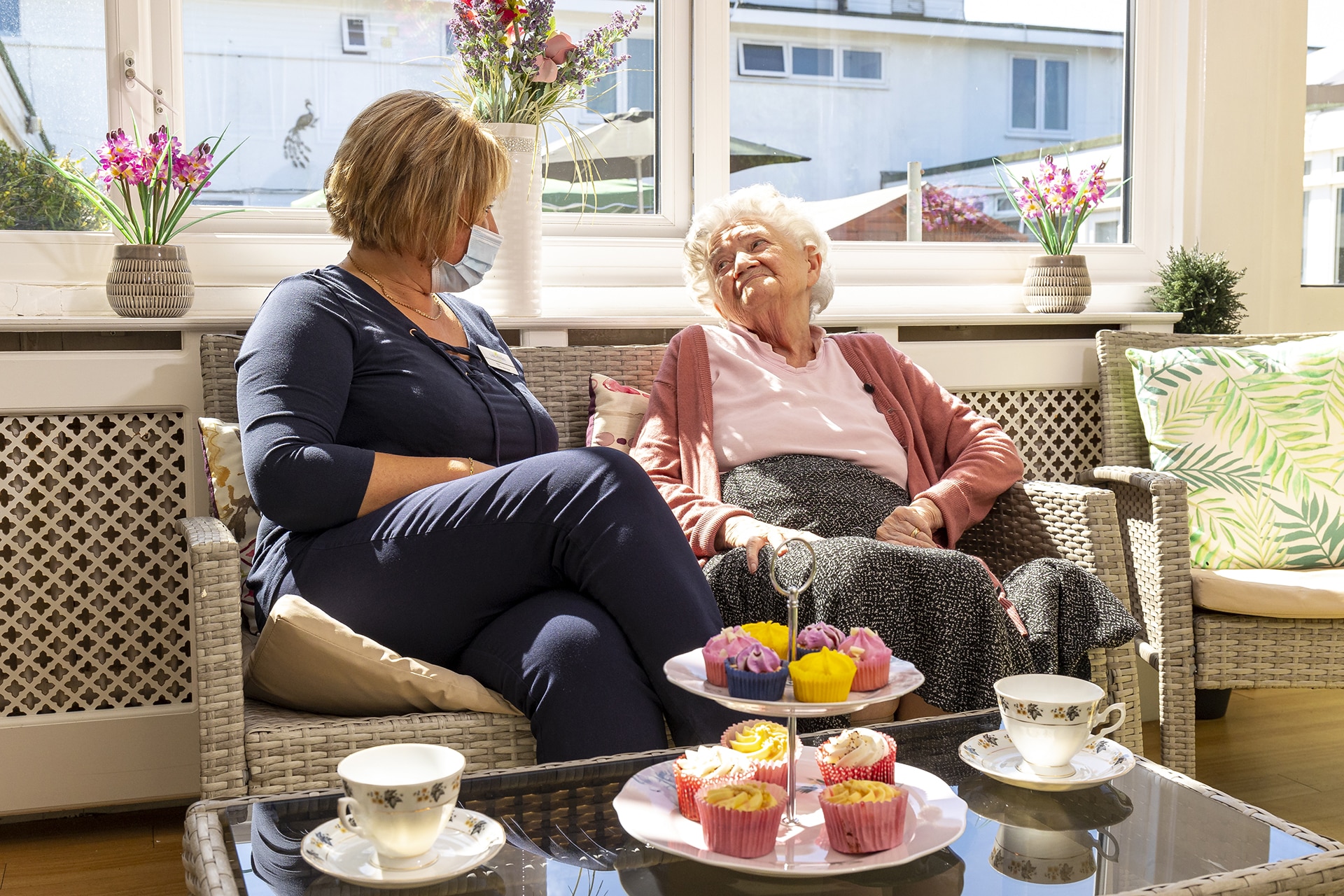 Resident and manager chatting in the sun room at Cavell House Care Home in Shoreham-by-Sea.