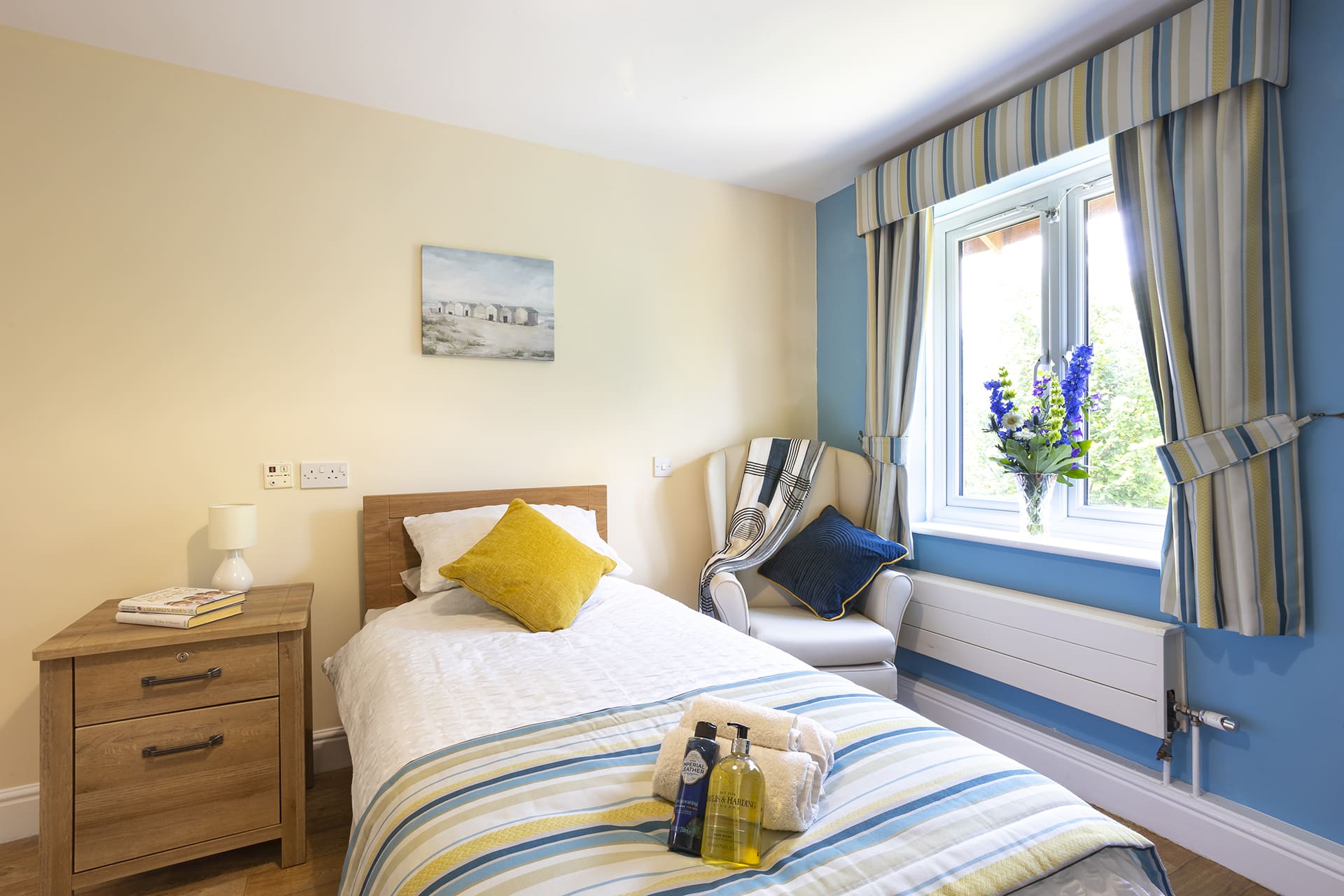 Bedroom with garden view with blue and yellow colour scheme at Lily House in Ely.