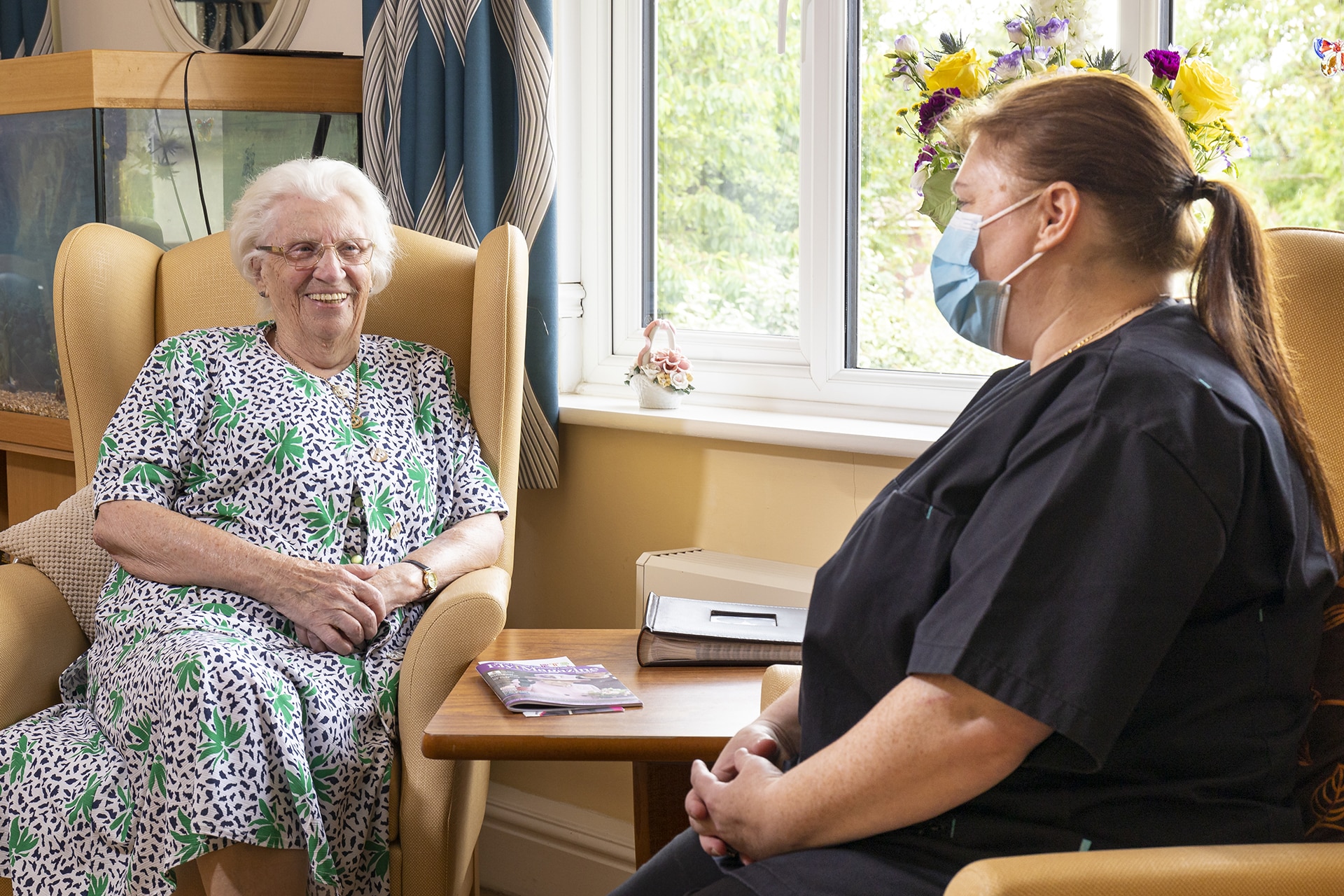 A resident and the home manager at Lily House Care Home in Ely enjoying a chat in the main lounge.