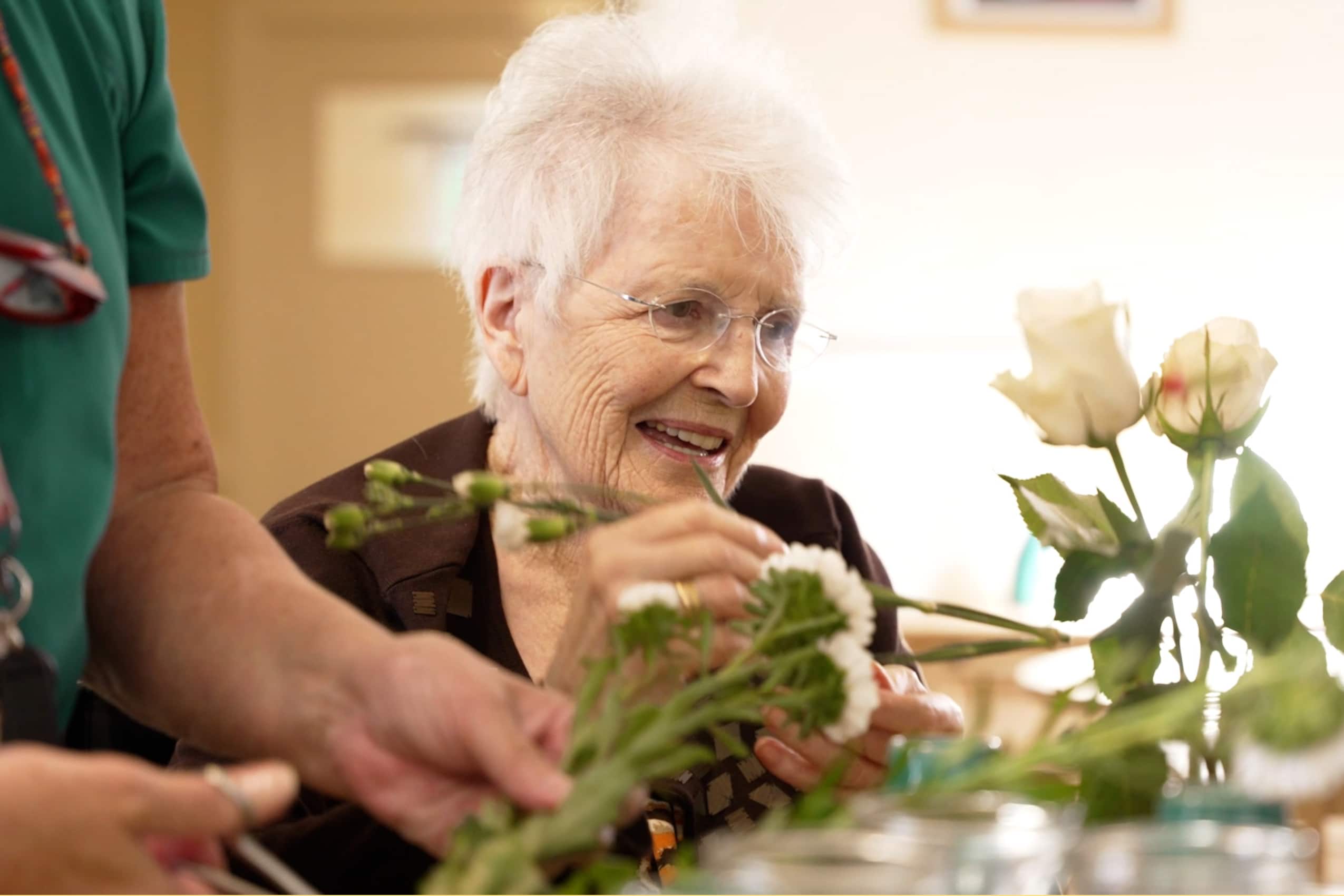A resident of Muirton House Care Home in Blairgowrie taking part in a group flower arranging activity.