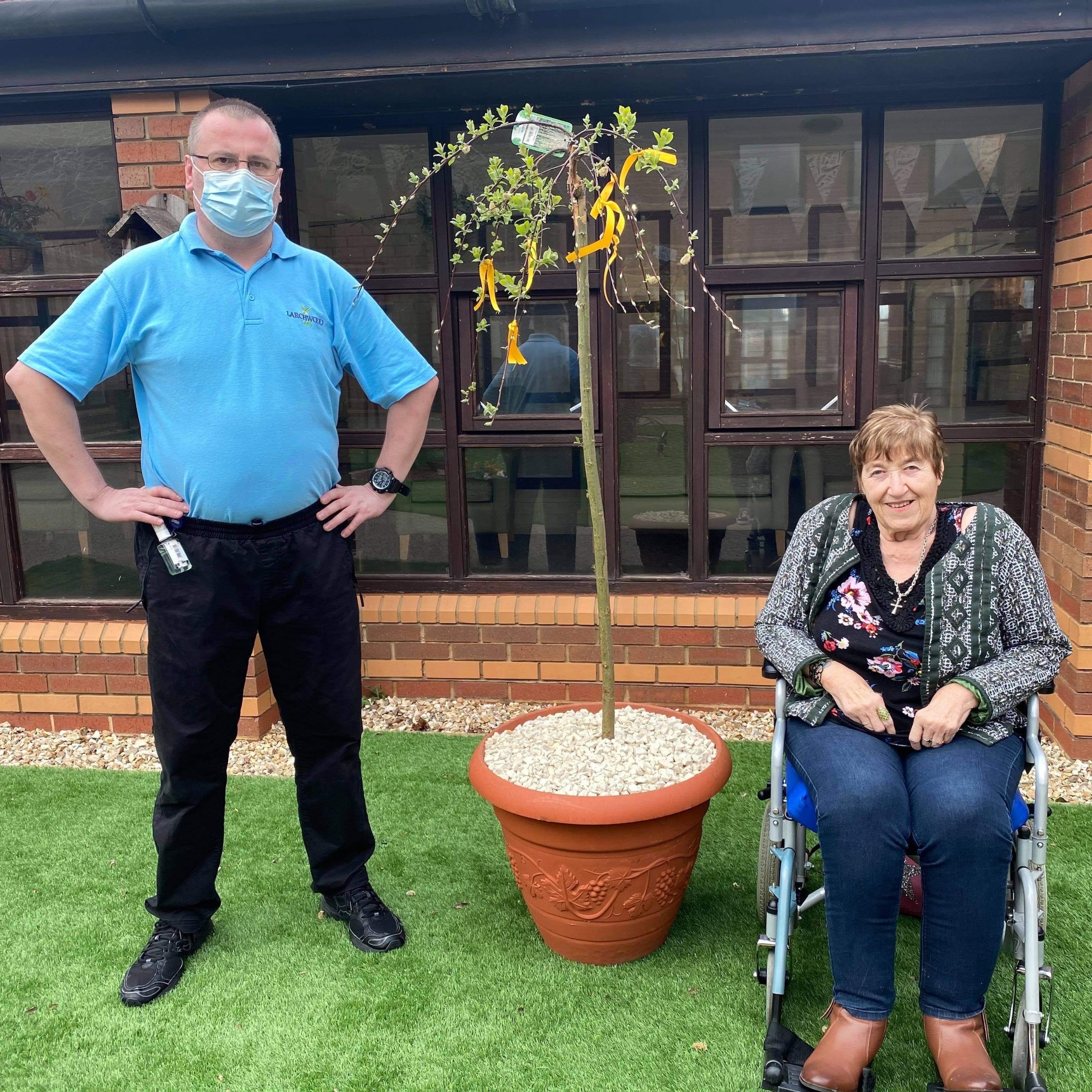 Oake Meadows Care Home resident Margaret Hill aged 77 and Wayne Farrington-Carter, Care Assistant with the home's memorial tree.