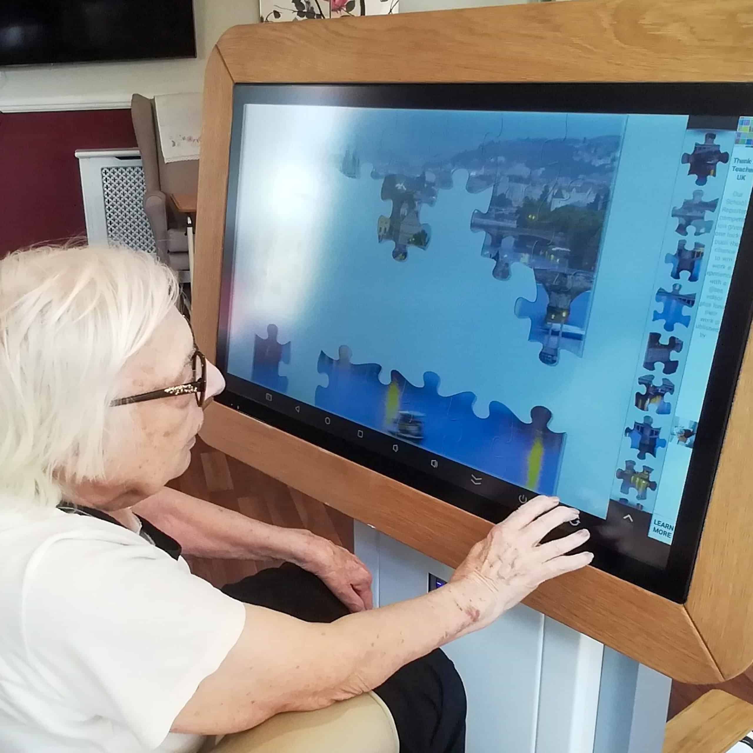 Stambridge Meadows Care Home resident, Joan Winsor enjoying a puzzle on the home's interactive table.