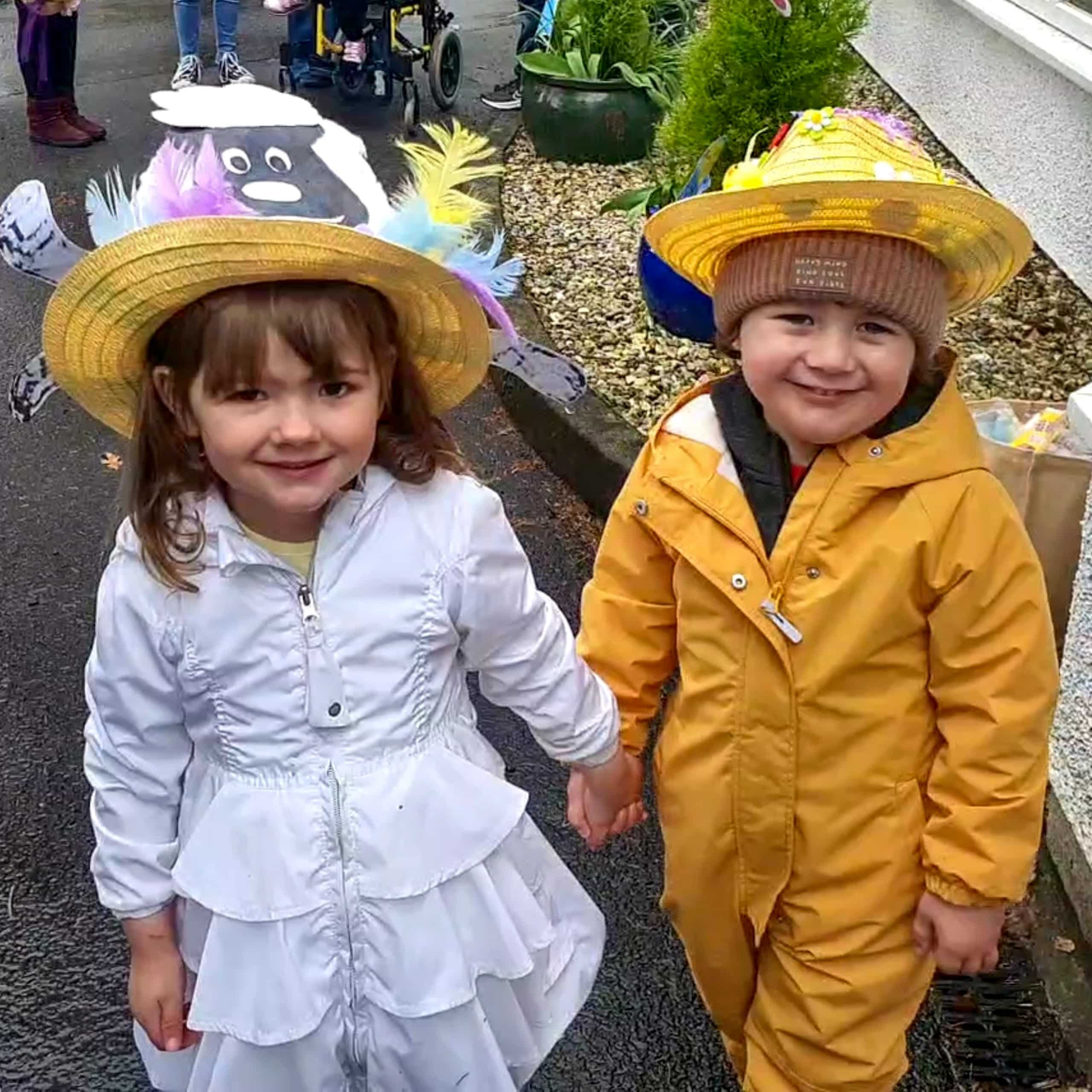 Two local children take part in Avonbridge Care Home's Easter Bonnet parade. One bonnet decorated with a cartoon lamb, the other with chicks.