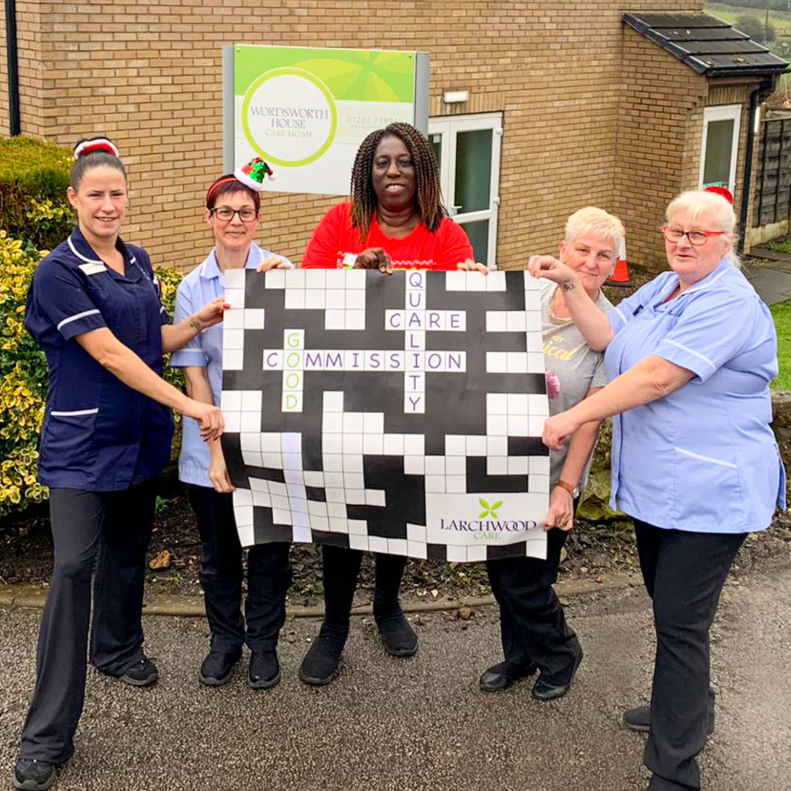 The team at Wordsworth House Care Home in Hapton near Burnley pose with the 'Good' CQC rating banner.